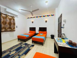 a living room with two beds and a table at ABAZIDO Nubian Guest House in Aswan