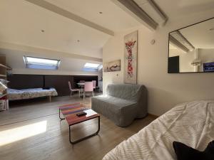 a living room with a bed and a couch and a table at Studio 4 personnes 3 lits Thionville Wifi Parking in Thionville