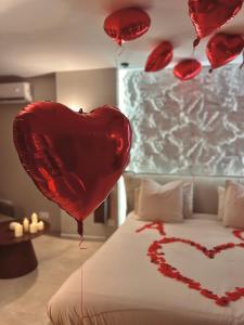 a bed with red balloons in the shape of a heart at L instant précieux in Marseille