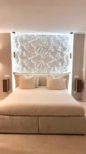 a large bed with white sheets and pillows at L instant précieux in Marseille