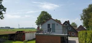 a house with a balcony on top of a building at Haus Königsstieg in Struckum +1 photo