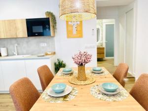 a dining room table with chairs and a vase of flowers at Apartamentos la Cárcava in Carcaboso