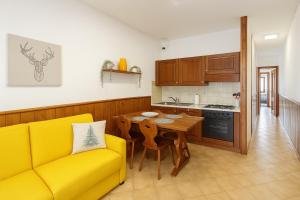 a living room with a yellow couch and a table at The Capriolo home in Tarvisio