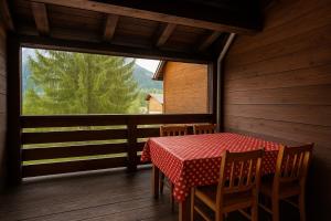 a dining room with a table and chairs and a window at Walk to Slopes & Free Parking -Capriolo Tarvisio in Tarvisio