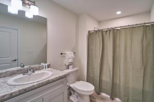 a bathroom with a sink and a toilet and a mirror at The Ruby 310 By Avada Properties in Pigeon Forge