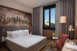 a hotel room with a large bed and a desk at NH Collection Milano Touring in Milan