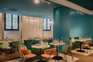 a dining room with tables and chairs in a room at NH Collection Milano Touring in Milan +62 photos