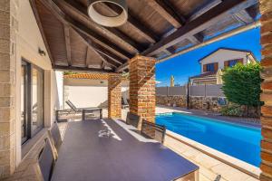 a patio with a table and a swimming pool at Villa Kvarner in Krk