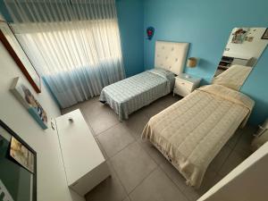 two beds in a small room with blue walls at Acantilados mar y pileta in Mar del Plata +11 photos