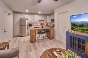 a kitchen with white cabinets and a large window at The Ruby 313 By Avada Properties in Pigeon Forge +11 photos
