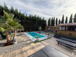 a backyard with a swimming pool and palm trees at Aux sources de Bali in Lavaur