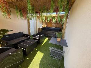 un patio con sedie nere, tavolo e piante di Aux sources de Bali a Lavaur