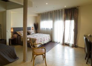 ein Schlafzimmer mit einem Bett und einem Stuhl darin in der Unterkunft Hotel Calabria in La Garriga