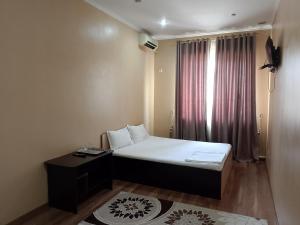 a small room with a bed and a window at Гостиница Шатыр in Saryaghash