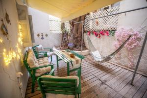 a balcony with a hammock and a table and chairs at Sunny Garden Apartment in central kolonaki Athens in Athens