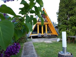 a cabin in a garden with chairs and flowers at Ferienpark Schellbronn - Wolfseeweg 11 und Wolfseeweg 9 in Schellbronn +4 photos