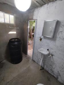 a bathroom with a sink and a trash can at Chalé Maison Blanche in Maracanã