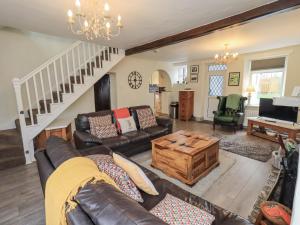 a living room with a couch and a coffee table at Smithy Cottage at Bowland Bridge in Bowland Bridge
