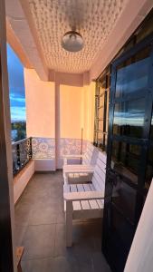 een balkon met witte stoelen en uitzicht op de oceaan bij Nanyuki Luxe Stays 2 in Nanyuki +1 foto