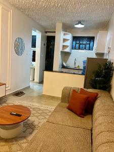 een woonkamer met een bank en een tafel bij Nanyuki Luxe Stays 2 in Nanyuki
