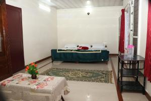 a room with a bed and a table in it at GEE VEE Home Stay in Munnar +1 photo