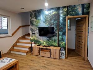 a living room with a wall mural of a forest at DreamHill in Bustryk
