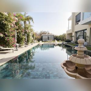 une piscine devant un bâtiment dans l'établissement Villa Fiori Luxury Italian Villa, Pool & Spa, Marrakech, à Douar bel Rhanodour