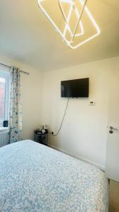 a bedroom with a bed and a television on the wall at The Guest Nook - Wollaton in Nottingham +17 photos