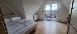 a bedroom with a bed and a door to a balcony at DreamHill in Bustryk