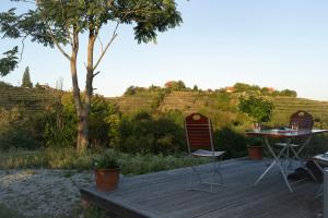 a wooden deck with two chairs and a table at Romantisches Tiny House mit Pool and Air Condition in Tržec