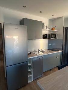 a kitchen with a refrigerator and a sink at L'instant fleuri in Saint-Hippolyte