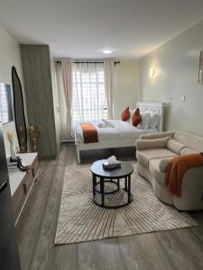 - un grand salon avec un lit et un canapé dans l'établissement Favour cozy stay 24, à Nairobi