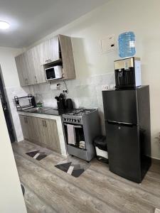 une cuisine avec un réfrigérateur noir et une cuisinière dans l'établissement Favour cozy stay 24, à Nairobi