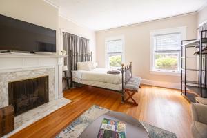 ダーラムにあるSpacious 2br In Grand Old Home, Downtown Durhamの暖炉とテレビのあるリビングルーム
