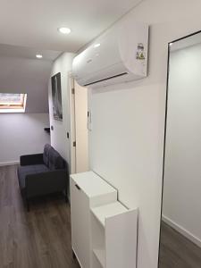 a living room with a black couch and a white wall at Rose house in Ribeira Brava