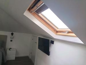 a skylight in a room with a television and a window at Rose house in Ribeira Brava
