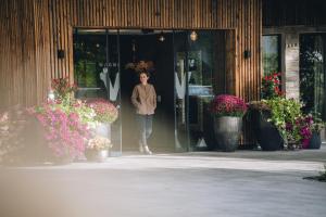a woman walking out of a building with flowers at Hotel Wagnerhof in Pertisau +135 photos