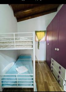 a bunk bed in a room with purple cabinets at Villa Liliana Piroska in San Giuseppe Jato