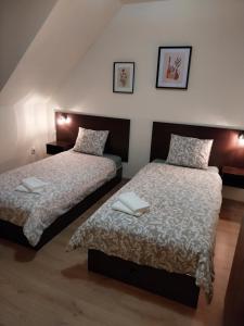 two beds in a bedroom with two towels on them at Hotelik pod Baranami in Siechnice
