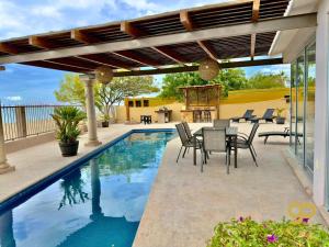a patio with a table and chairs next to a swimming pool at Beachfront Compound, Pool, BBQ, Best for Groups in Refugio