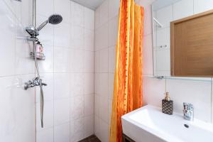 baño con cortina de ducha naranja y lavamanos en 5 min from Port - free private parking - 1BR, en Tallin 27 fotos más