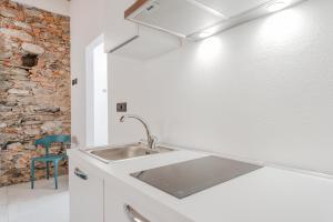 a kitchen with a sink and a brick wall at La Dimora delle Masche in Levone +47 photos