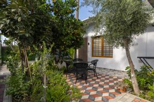 a patio with a table and trees in front of a house at Gus House Vlore in Vlorë
