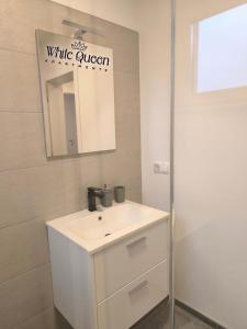 a white bathroom with a sink and a mirror at White Quenn Apartments in Sanski most +19 photos