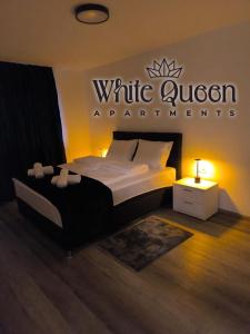 a bedroom with a bed with a sign on the wall at White Quenn Apartments in Sanski most