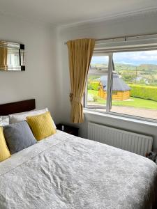 a bedroom with a bed and a large window at Cullentra House in Cushendall
