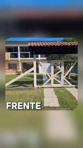 a fence with a red roof in front of a building at Casa Andar Térreo - Balneário Nordeste - Imbé - RS in Imbé