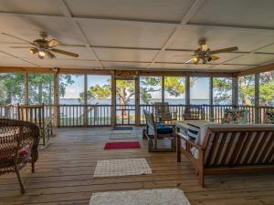 Sun N Sand BeachesにあるBill's Bay Breezeの天井ファンと窓のあるポーチ