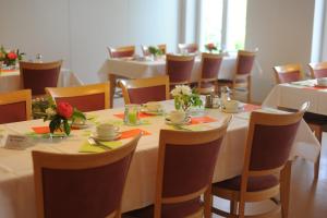 ein Esszimmer mit Tischen und Stühlen mit Blumen in der Unterkunft Komenský Gäste- und Tagungshaus in Herrnhut
