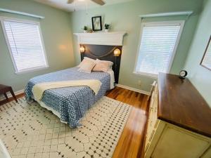 a bedroom with a bed and two windows at Midtown Cottage- Walk to Whole Foods in Tallahassee